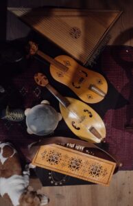 Gruppo di strumenti medievali: una symphonia, antenata della ghironda, un tamburello, due vielle da braccio, un'arpa salterio (arpa con la cassa armonica trasversale in mezzo)